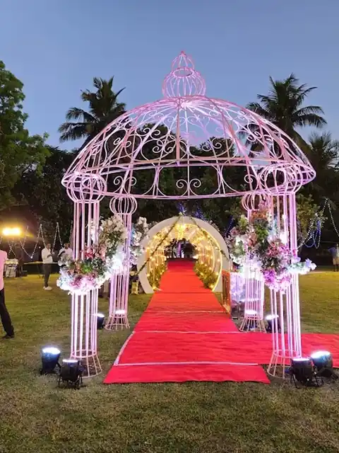 Pink floral gazebo over a red carpet at dusk