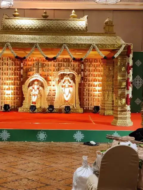 Temple-style mandapam in gold on a red stage